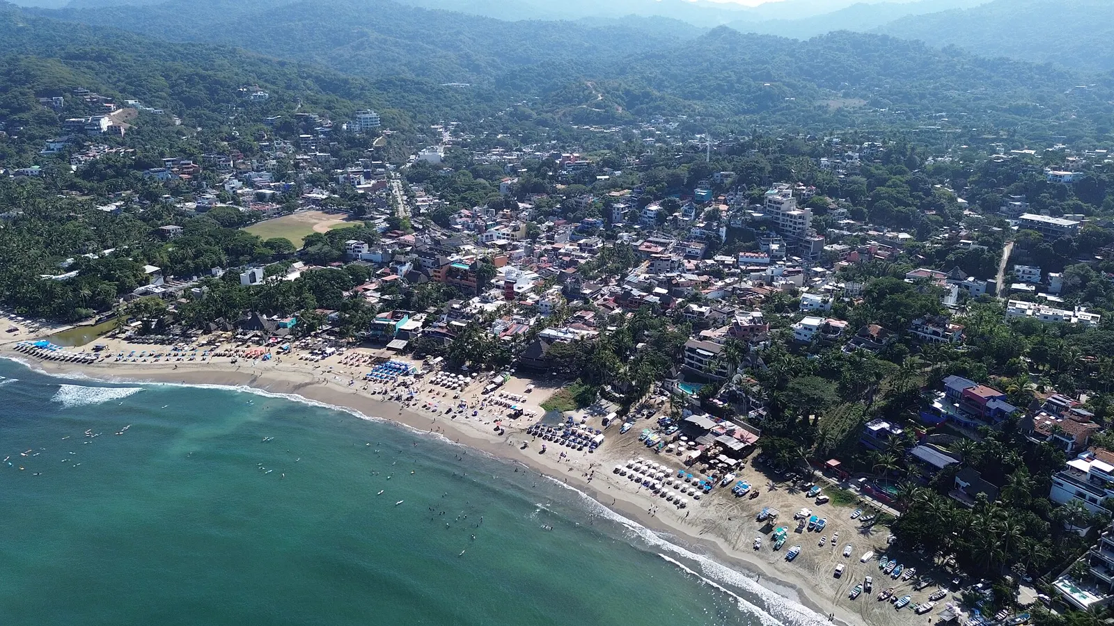Vista aérea de Sayulita: la playa, el pueblo y los cerros cubiertos de selva