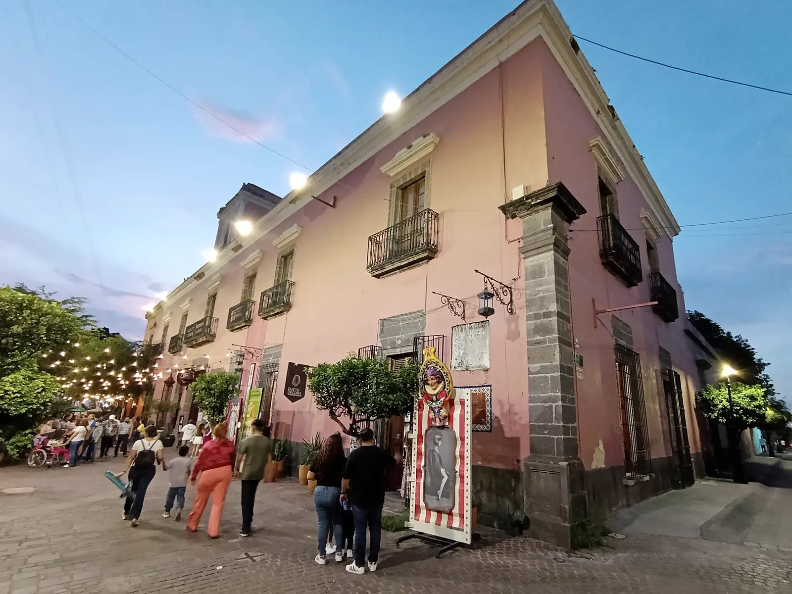 Calle de Tlaquepaque al atardecer, con casonas y gente paseando