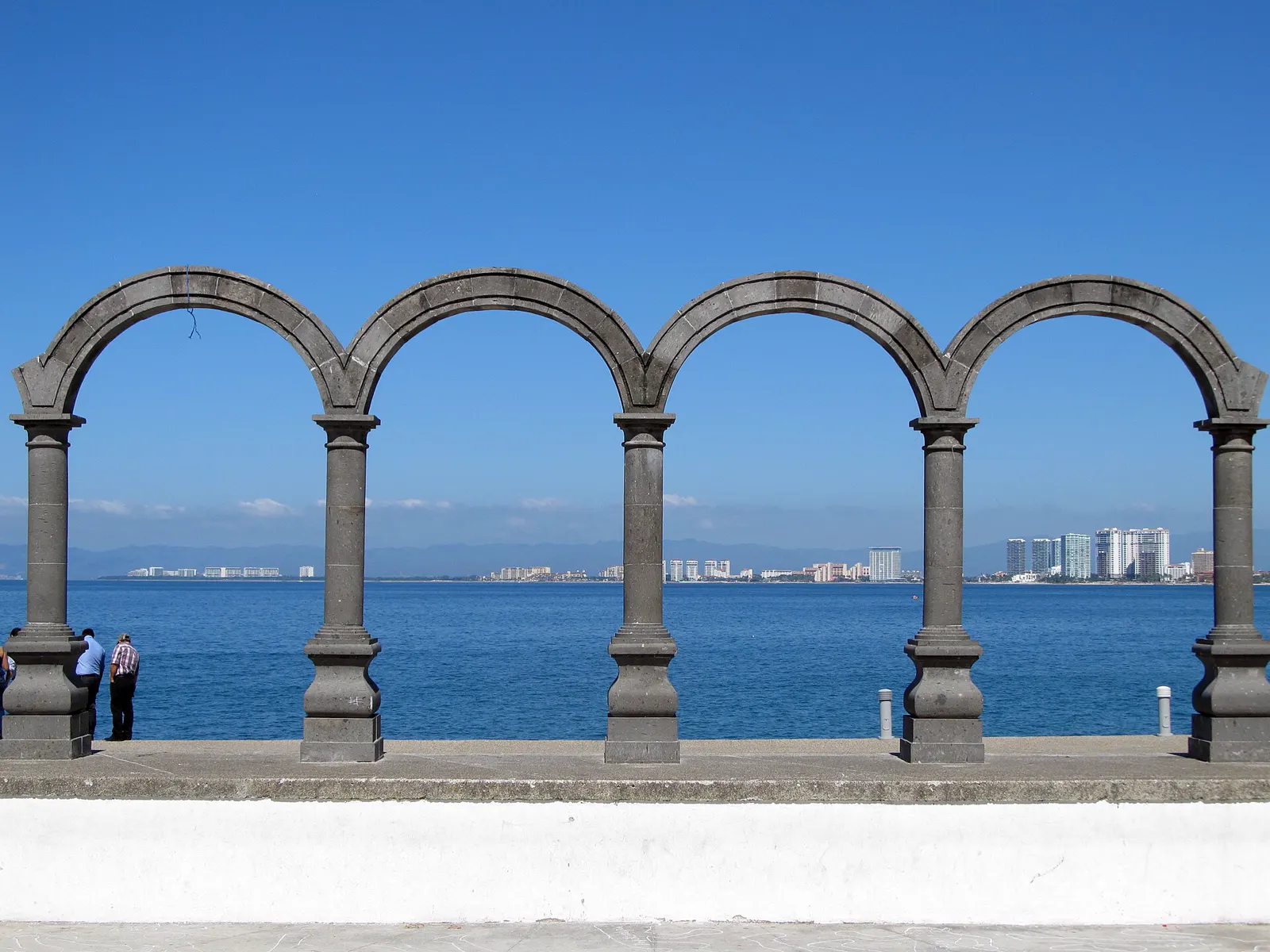 Los Arcos del Malecón de Puerto Vallarta frente al mar, con la costa norte de la bahía al fondo